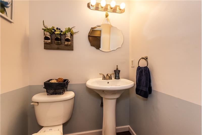 Powder room has new vanity, updated toilet, new luxury vinyl plank flooring, fresh paint.