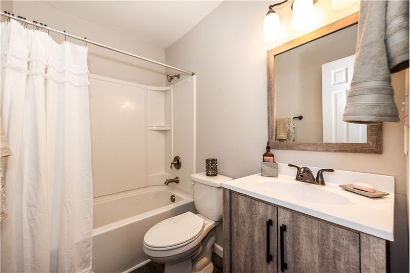 Hall bath shared by the two secondary bedrooms features brand new vanity, updated toilet and light fixture, new flooring.