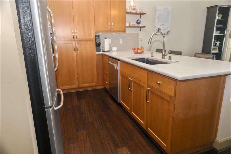 Open Kitchen with Plenty of Custom Maple Cabinets and Engineered Hardwood  Floors.