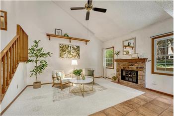 Bright, inviting vaulted living room featuring a wood burning fireplace to cozy up on chilly nights.