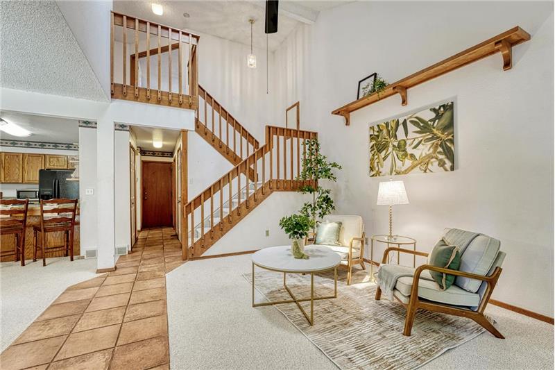 View of the entry, living room, and stairs to the upper level.