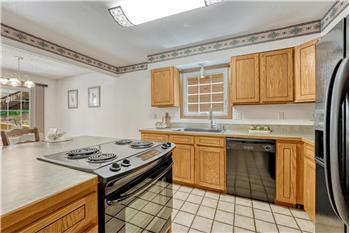 Appliances include an electric range oven, dishwasher, and side by side refrigerator.