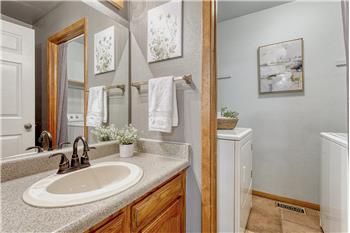 The powder bathroom has a vanity and mirror and entrance into the laundry room with washer and dryer that stay.