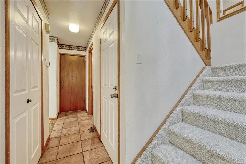 Hallway with garage access and stairs to the upper level.