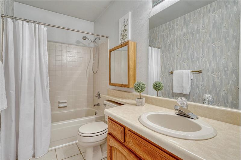 Upper level full bathroom with vanity, mirror, and tub/shower.