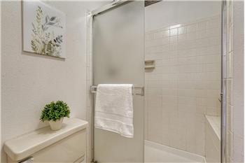 Primary bathroom with tiled shower and built-in seat.