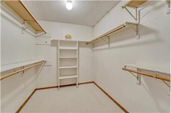 Walk in closet with organizer and built in shelves in the primary bedroom.