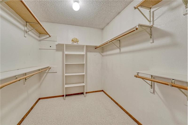 Walk in closet with organizer and built in shelves in the primary bedroom.