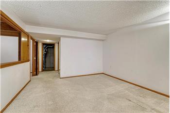 Basement family room with view into the utility area.