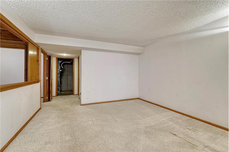 Basement family room with view into the utility area.