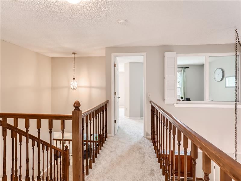 This catwalk helps vault the room below and connects the primary bedroom suite to the other two bedrooms and staircase helps giv