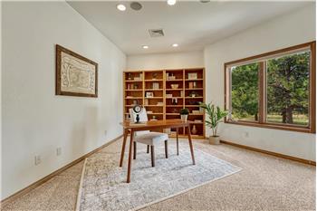 Main level office off the entry with included shelving.