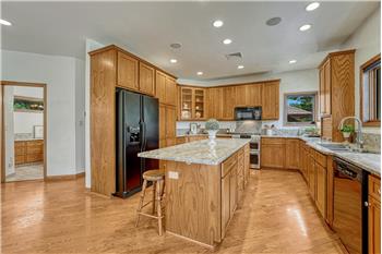 Spacious kitchen with abundant storage, roll out shelving, recessed lighting, granite counters, and cabinet pantry.