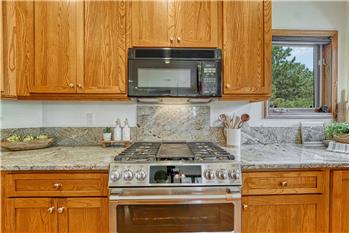 Double oven gas range with granite backsplash.