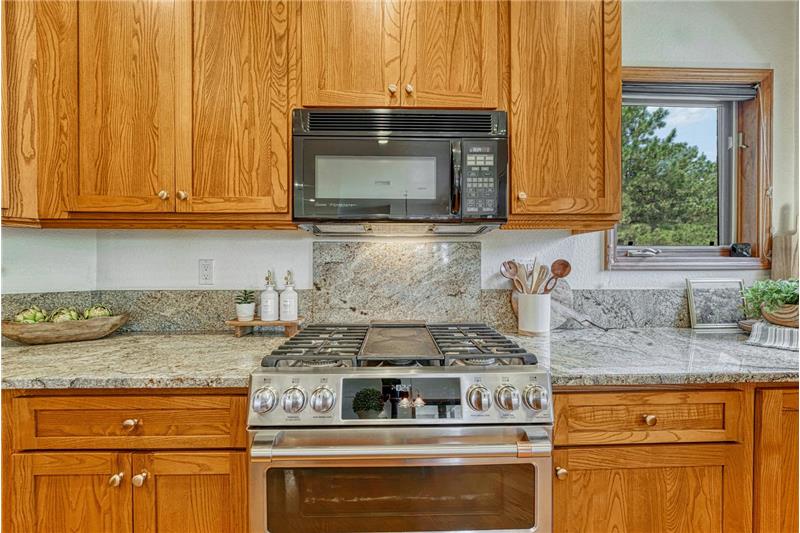 Double oven gas range with granite backsplash.