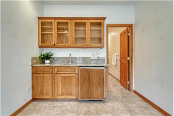 Wet bar with granite counters and beverage fridge.
