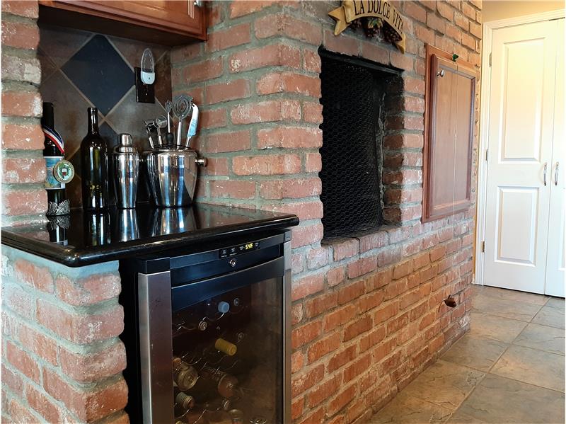 Integrated wine fridge, subtly and beautifully wrapped in brick, granite and stone.