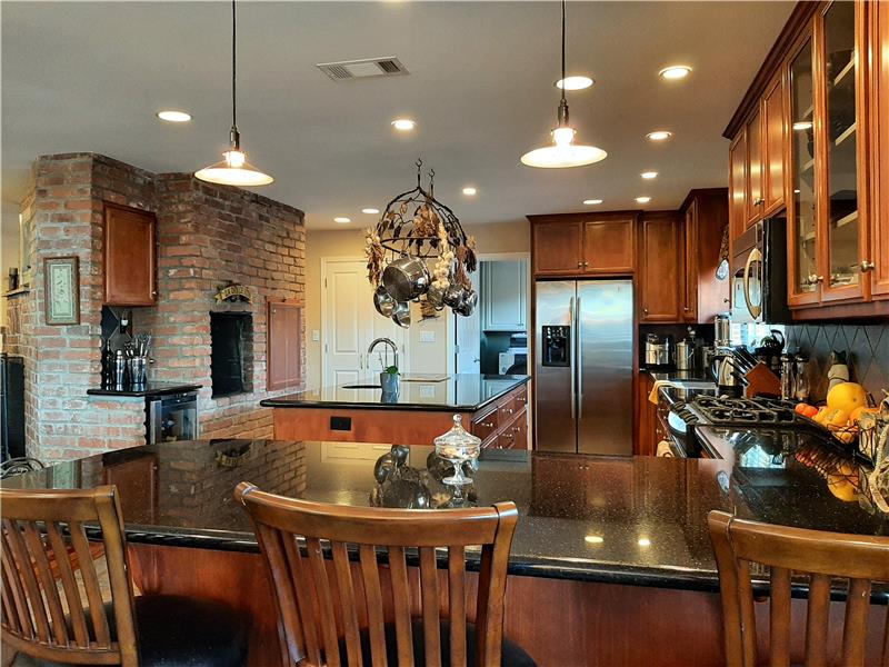 Stainless appliances shine bright with perfectly positioned pendant and recessed light fixtures.