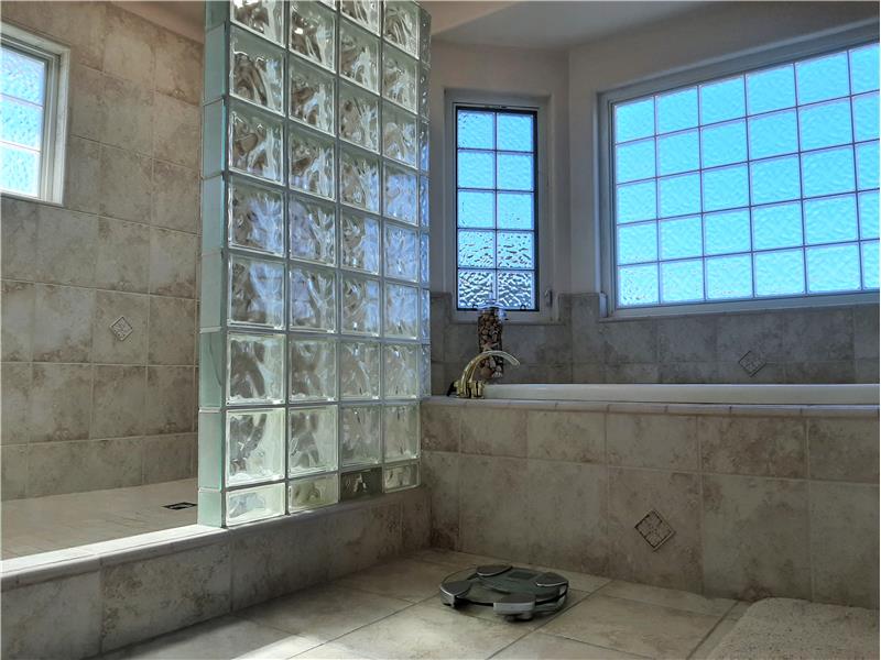 Separate jacuzzi tub and shower; both share glass block. Of note, this bathroom is really good sized!!