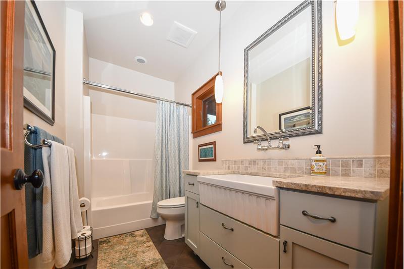 Main floor full bathroom with low-maintenance one piece shower/tub, apron-farmhouse kitchen sink, and MARBLE countertops!