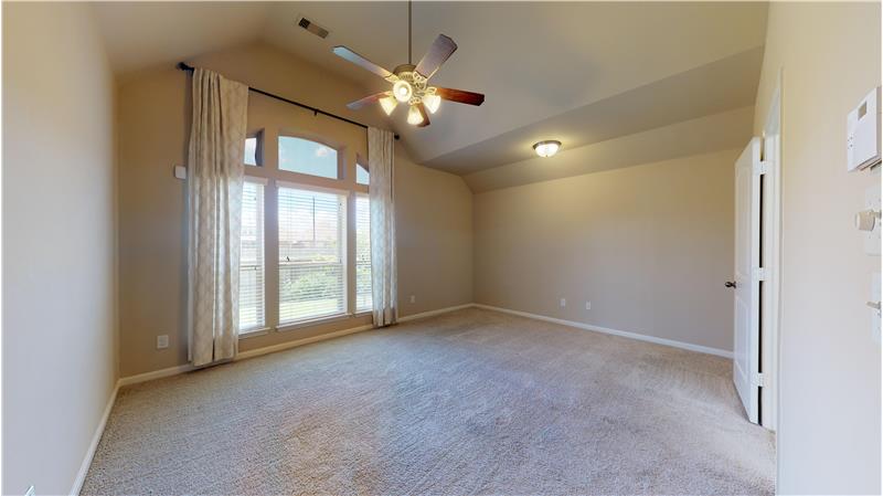 Master bedroom is spacious and has a view of the back yard.