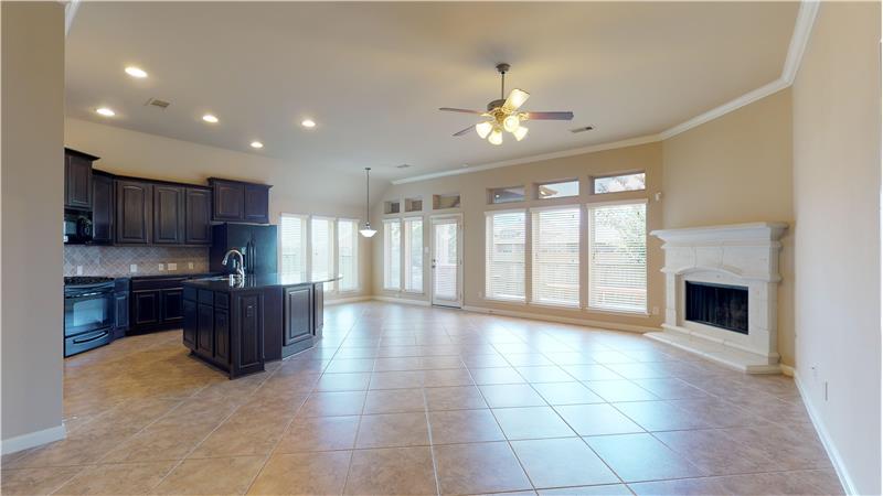 The tile floored family room features a corner fireplace and is open to the kitchen and breakfast area.