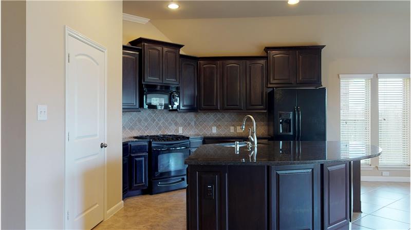 The large kitchen features granite counters and large granite island, that is open to the family room and breakfast area.