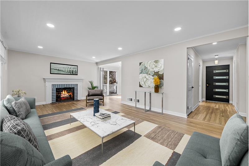 Grand welcoming Living area with wood burning fireplace picturesque windows overlooking the large backyard  