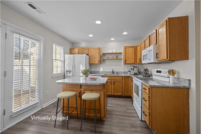 Bright and sunny kitchen features new granite counters, new range, new dishwasher, new undermount sink.