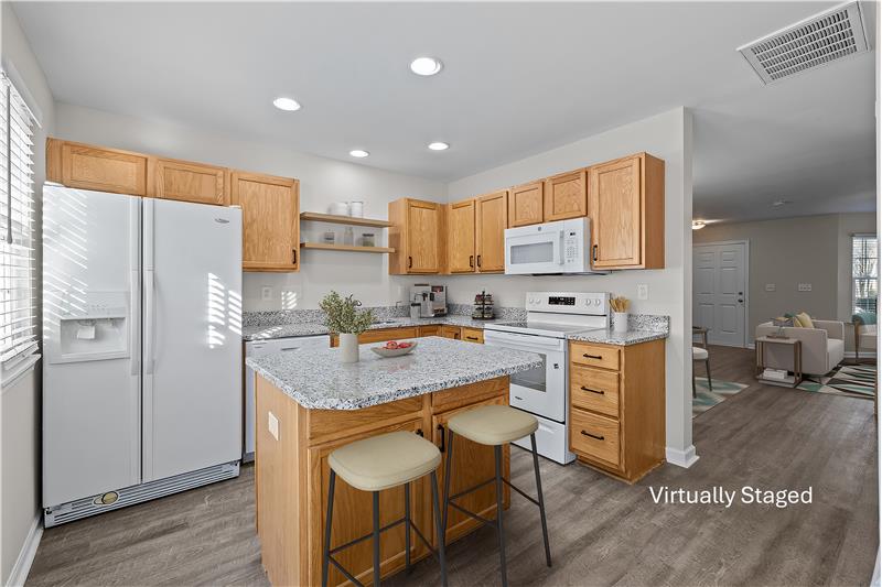 Center island with storage and overhang for seating. Easy access from kitchen to dining/living areas.