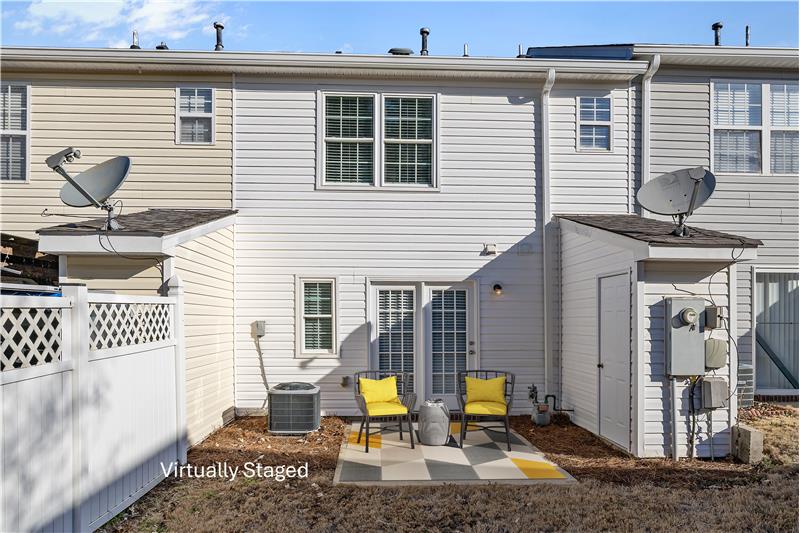 Exterior storage room adjacent to the patio, privacy fence on right side.