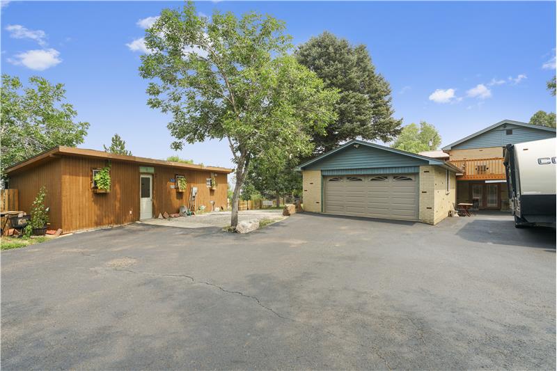 Driveway showing workshop at left and oversized garage and RV parking at right
