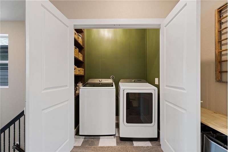 Laundry with custom cabinets.  Home has a tankless water heater.