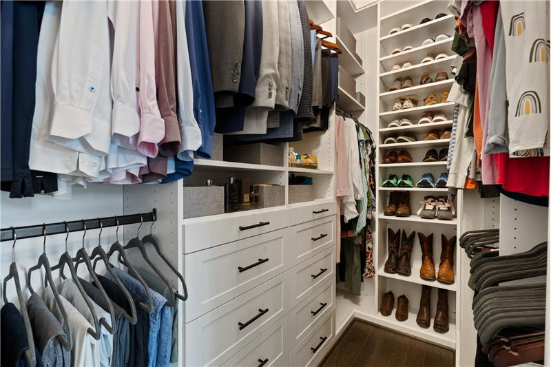 Primary closet with custom cabinets.