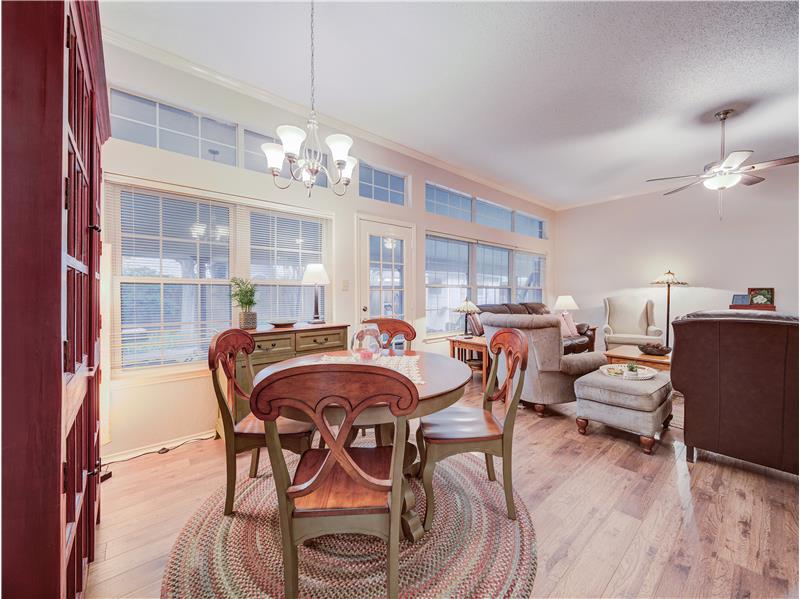 Dining room with ceiling fan with notable chandelier, a textured ceiling, light hardwood / wood-style floors