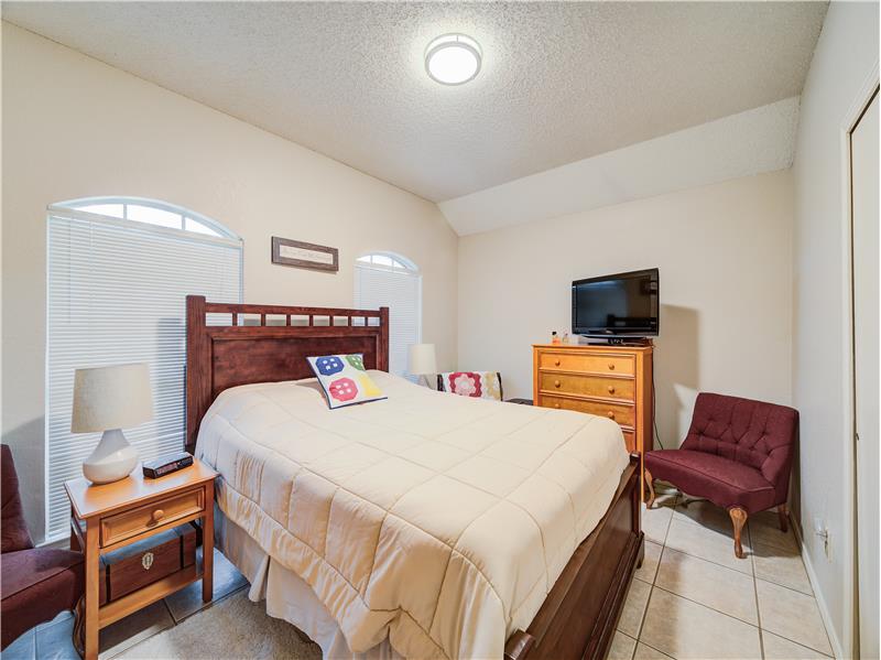 Bedroom featuring lofted ceiling, light tile flooring