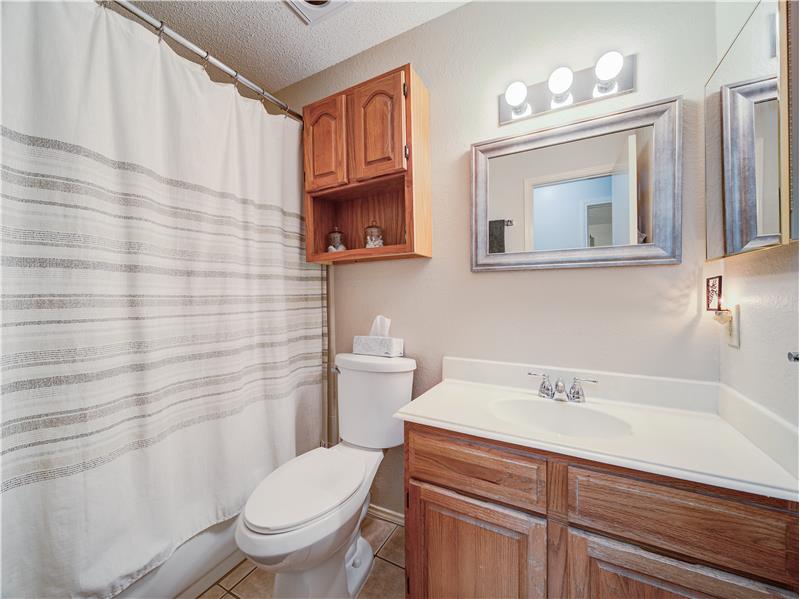 Bathroom with toilet, tile floors, and large vanity
