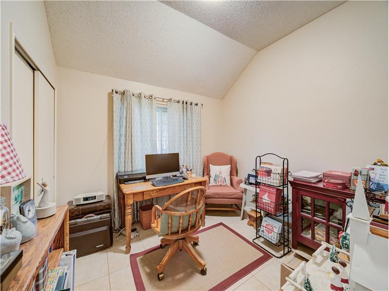 Bedroom/Office space with light tile floors, and lofted ceiling