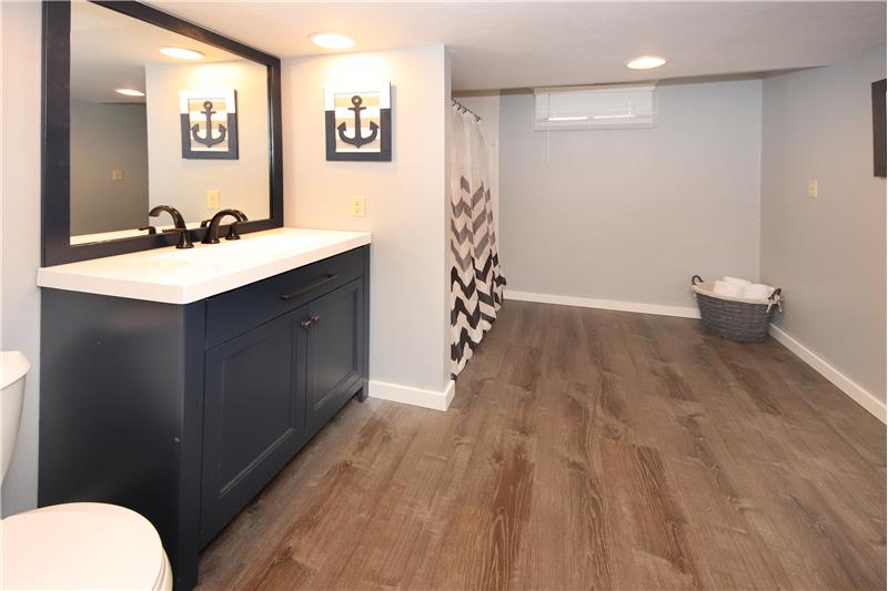 Remodeled full bath in basement with beautiful new flooring and sink vanity. Very large!!