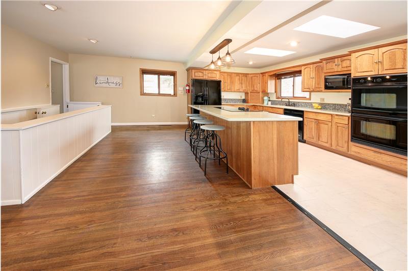 Open kitchen features double ovens, tile backsplash, counter top and storage space galore, breadbox, and two skylights!