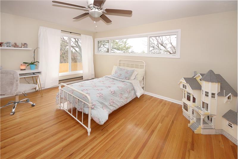 Bedroom 3 with plentiful windows, hardwood flooring, and ceiling fan