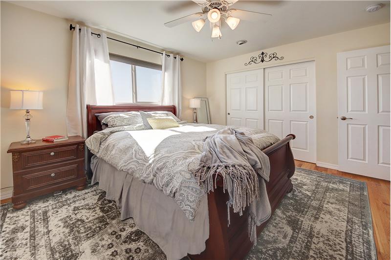Master bedroom with hardwood flooring and ceiling fan