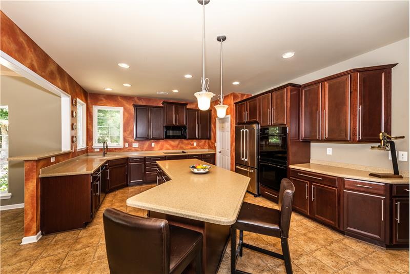 Cook's kitchen with tons of counter space, storage space, and large island with over-hang for seating.