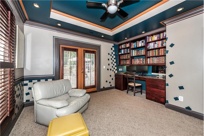 Office privately situated at the back of the home. Features trey ceiling, custom paint finishes, built-in desk/shelves.
