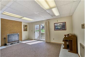 Very Large Downstairs Family Room with Brick Surround Wood Fireplace and French Doors Leading to the Back Yard.