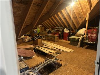 Several storage areas upstairs with flooring and lights.