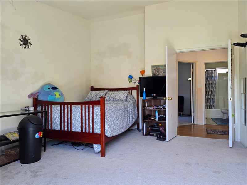 Primary bedroom with doubledoor entry, vaulted ceiling, and flexible layout.