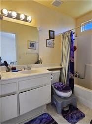 Primary bath with solidsurface counter, tile flooring, and full tub/shower.