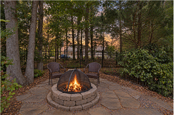 Backyard fire pit creates a cozy spot for relaxing on cool evenings.