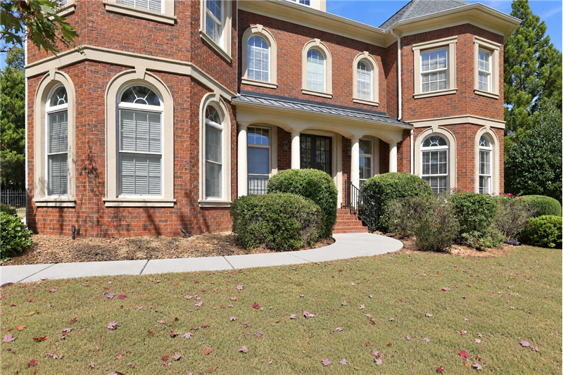 Curved walkway leads to the covered front entry where stately columns and double front doors create an impressive entry.